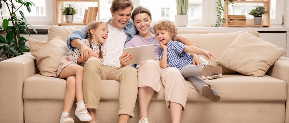 Familie sitzt zusammen auf einem Sofa