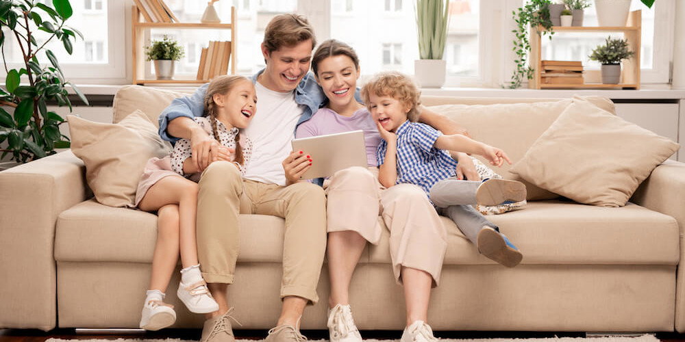 Familie sitzt zusammen auf einem Sofa