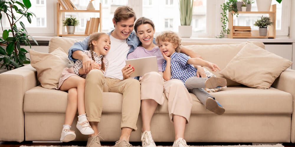 Familie sitzt zusammen auf einem Sofa