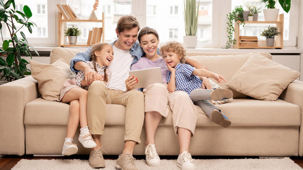 Familie sitzt zusammen auf einem Sofa