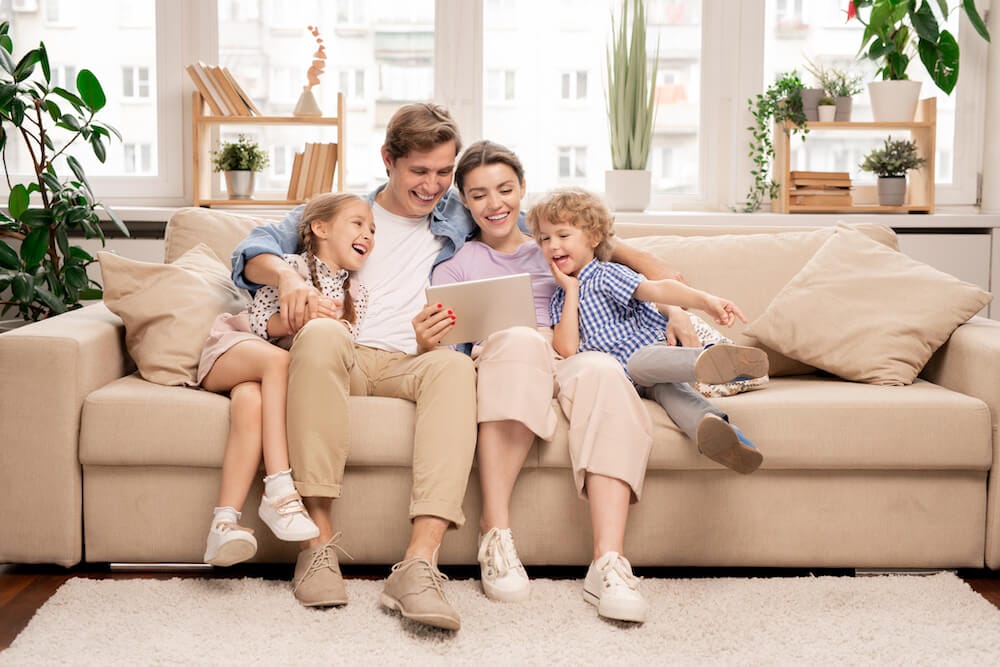 Familie sitzt zusammen auf einem Sofa