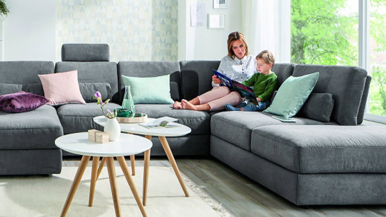 Runde und ovale Couchtische neben einem Sofa mit einer Mutter und einem Kind