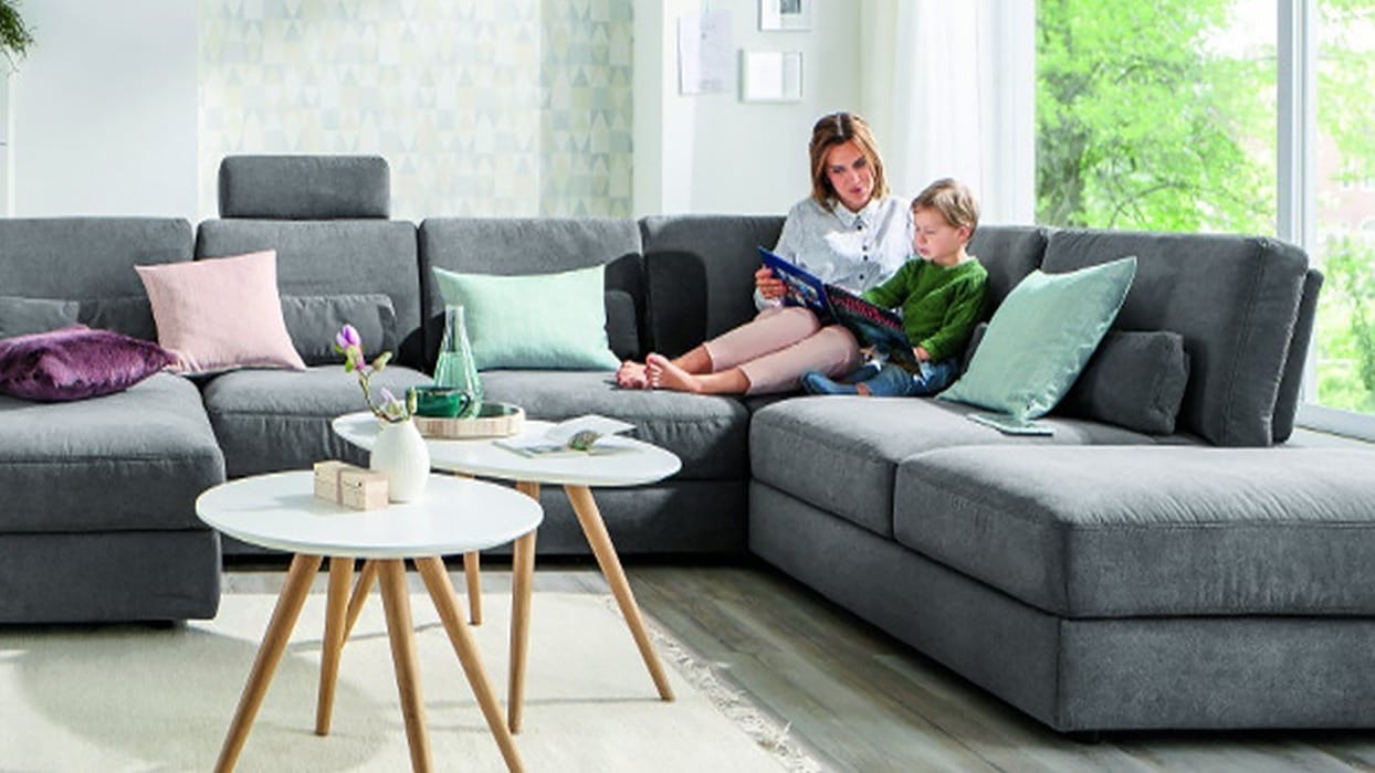 Runde und ovale Couchtische neben einem Sofa mit einer Mutter und einem Kind