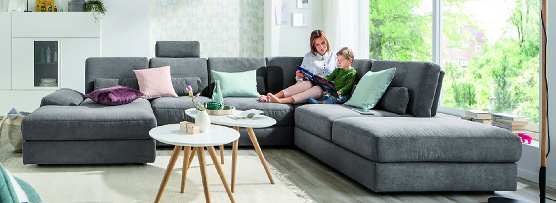 Runde und ovale Couchtische neben einem Sofa mit einer Mutter und einem Kind