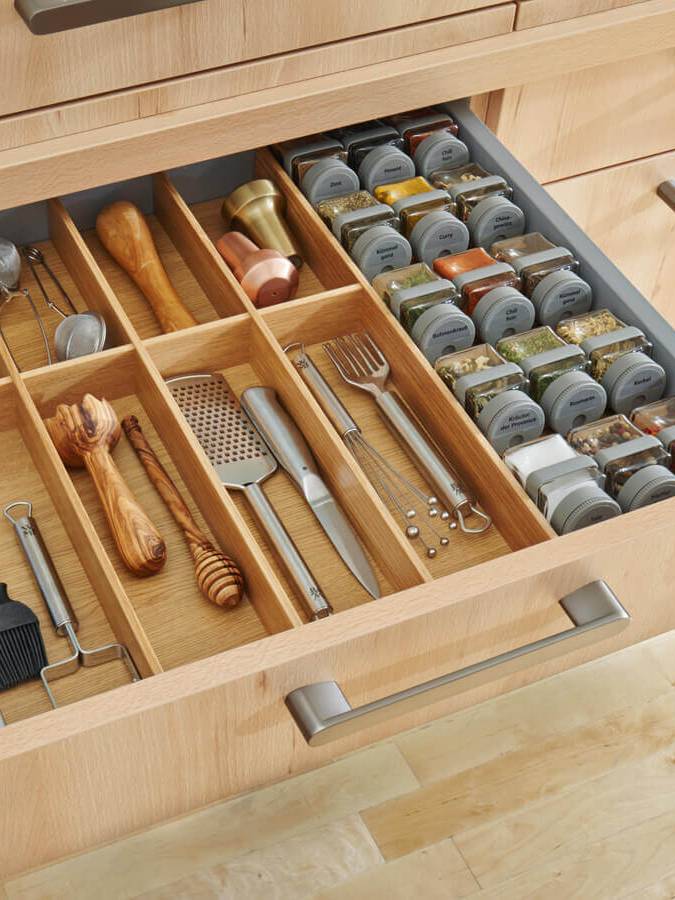 Schublade einer Holzküche mir Küchenutensilien und einem Extrafach für Gewürze