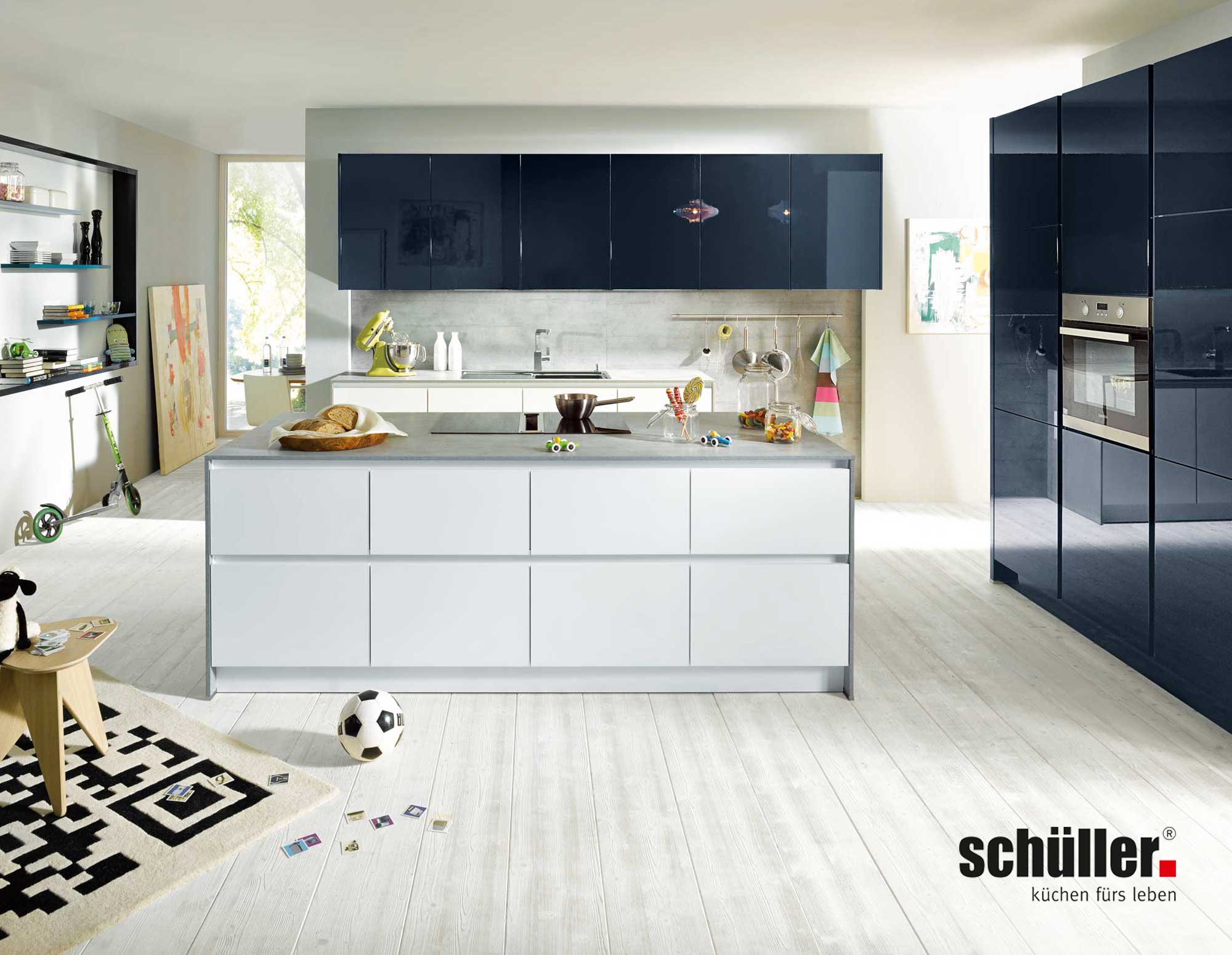 Inselküche von Schüller mit weißer Kücheninsel und dunklen Fronten
