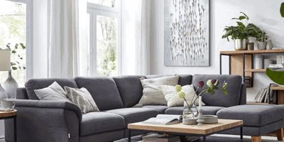 Gemütliches Wohnzimmer, graues Sofa weißer Teppich, helle Vorhänge im Wohnzimmer,
