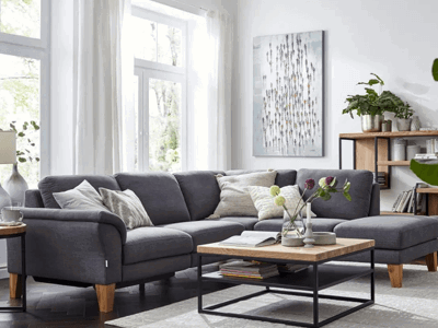Gemütliches Wohnzimmer, graues Sofa weißer Teppich, helle Vorhänge im Wohnzimmer,