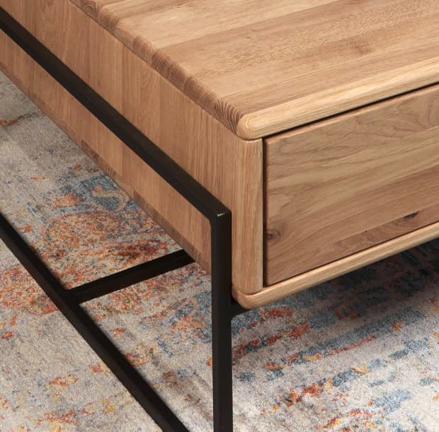 Ecke eines Couchtisches aus Massivholz der einen Metallrahmen als Untergestell hat