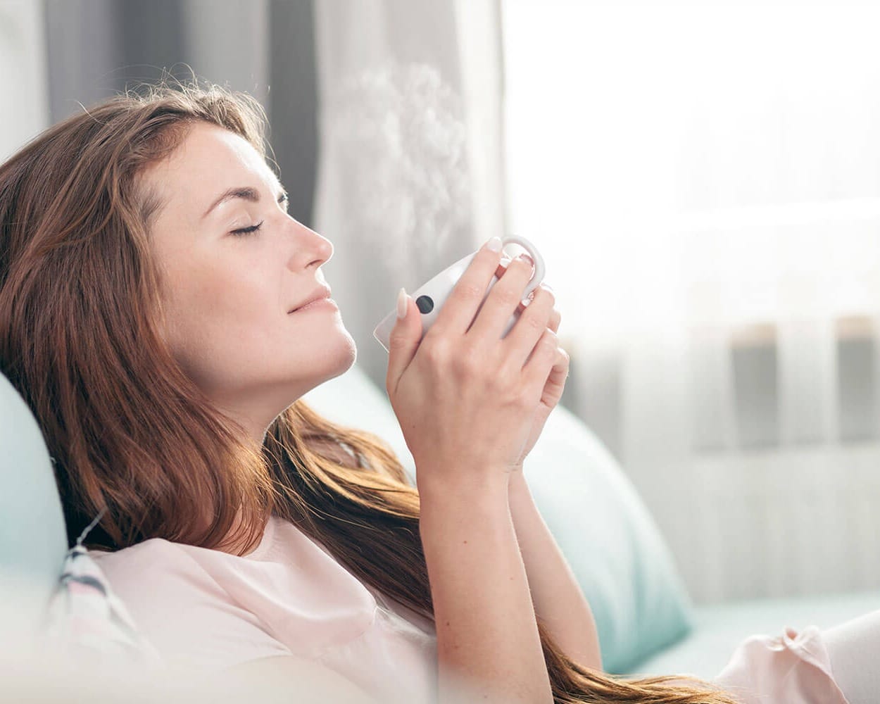 Wellnessoase Wohnzimmer, gemütliches Wohnzimmer, Entspannung pur zuhause im Wohnzimmer, eine warme Tasse Tee Kaffee zuhause in Ruhe, traumhafte Ruhe in der Wohnung, Alltagssorgen vergessen zuhause