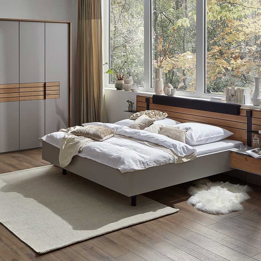 Modernes Schlafzimmer mit Polsterbett, großem Kleiderschrank und bodentiefen Fenstern.