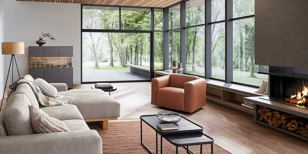 Gemütliches Wohnzimmer, Wohnzimmer mit Kamin, Holzdecke und großen Fenstern