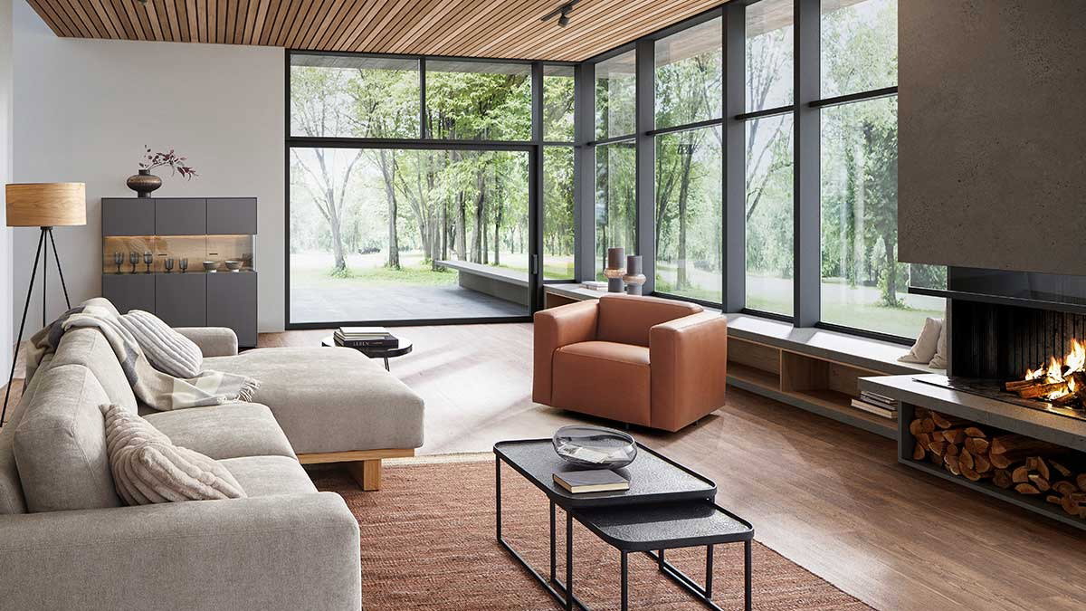 Gemütliches Wohnzimmer, Wohnzimmer mit Kamin, Holzdecke und großen Fenstern