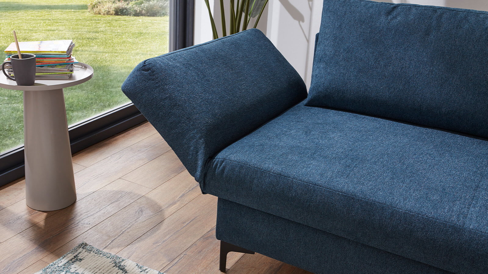 Großzügiges Schlafsofa mit Stoffbezug in verschiedenen Farben, komfortabler Sitzfläche, breiten Armlehnen, zwei Rückenkissen und schwarzen Designfüßen aus Metall