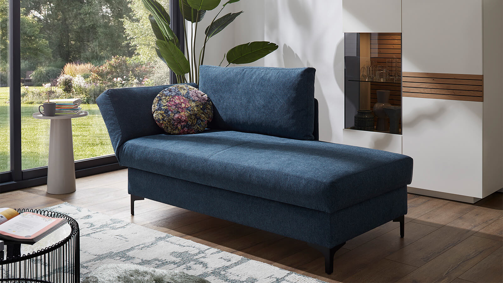 Großzügiges Schlafsofa mit Stoffbezug in verschiedenen Farben, komfortabler Sitzfläche, breiten Armlehnen, zwei Rückenkissen und schwarzen Designfüßen aus Metall