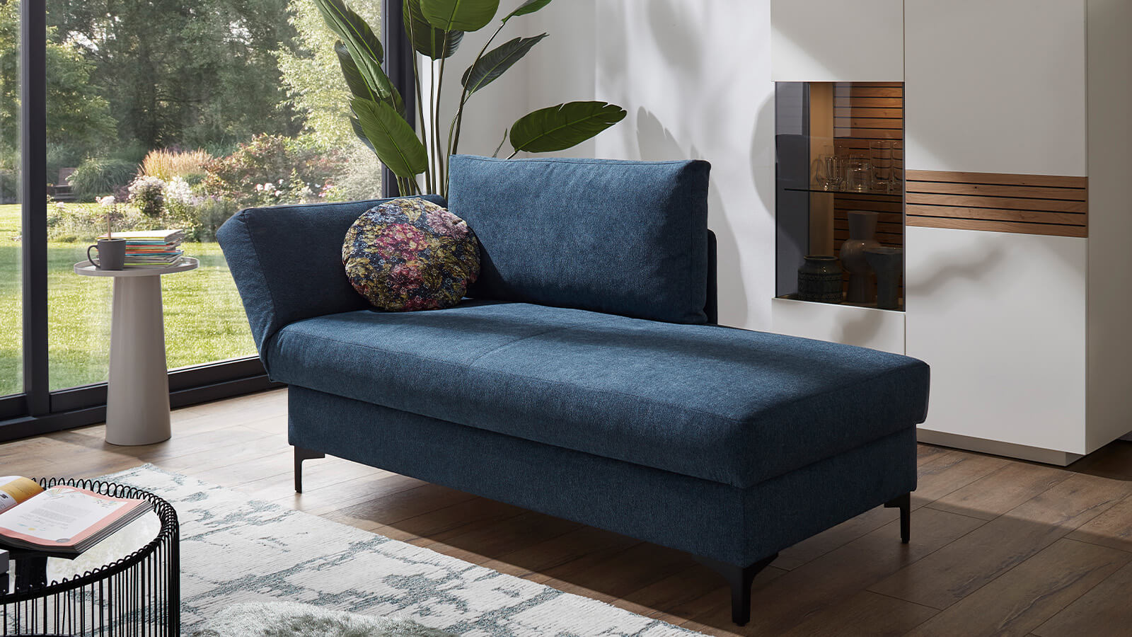 Gemütliches Schlafsofa mit Stoffbezug in verschiedenen Farben, einladender Polsterung, breiten Armlehnen und schwarzen Metallfüßen für eine wohnliche Atmosphäre
