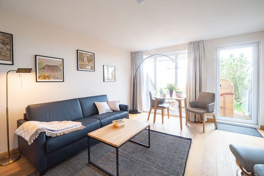 Modernes, gemütlich eingerichtetes Wohnzimmer mit heller Couch und natürlichem LichteinfallDieses helle Wohnzimmer zeigt, wie wichtig ein stimmiges Einrichtungskonzept ist: Helle Farben, weiche Textilien und natürliche Materialien schaffen eine warme, einladende Atmosphäre. Ideal, um sich rundum wohlzufühlen.