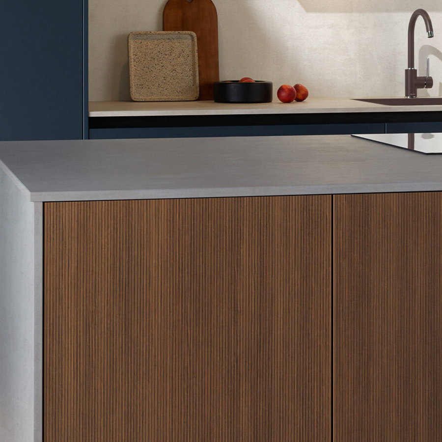 Moderne Kücheninsel mit geriffelter Holzfront und heller Arbeitsplatte.