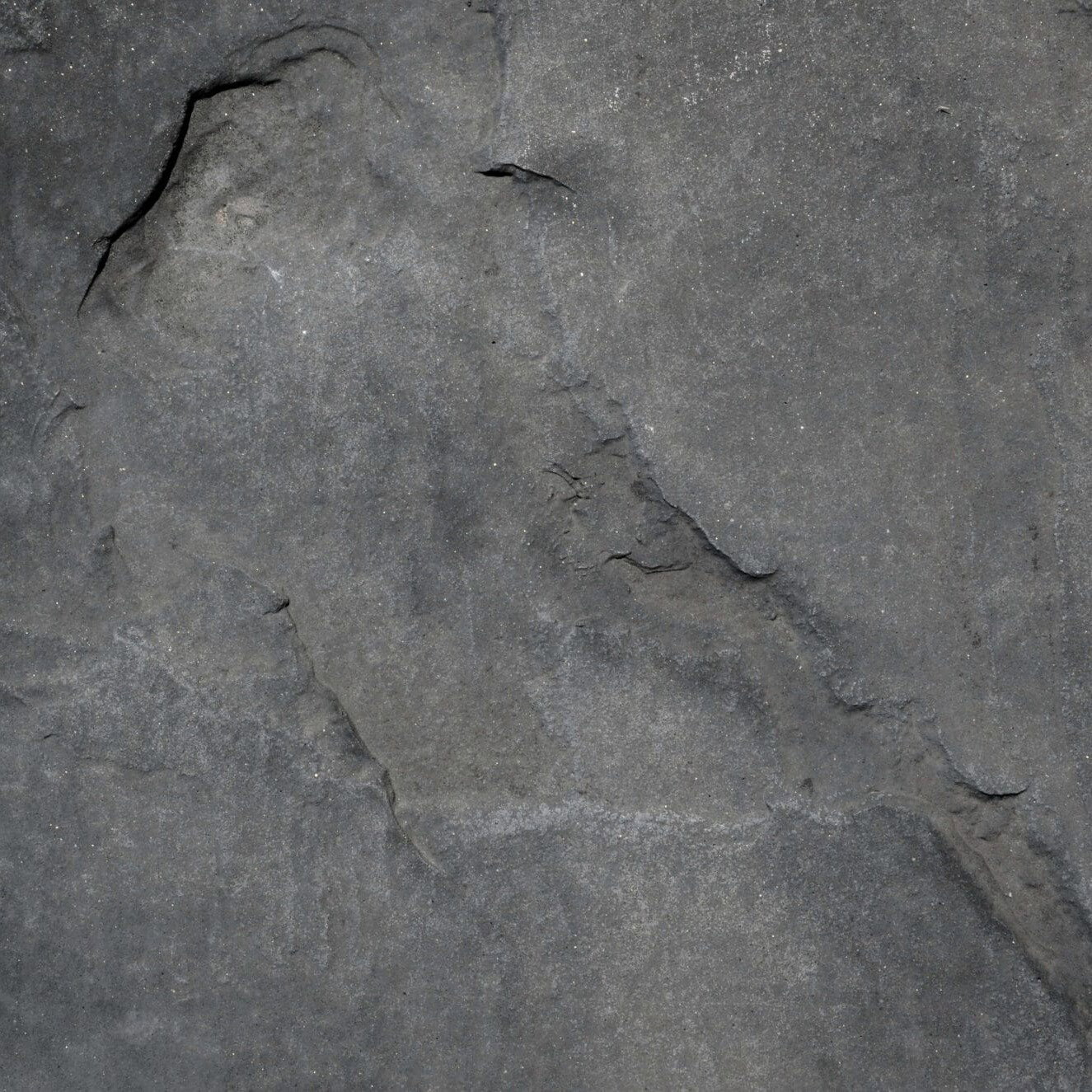 Detailaufnahme einer grauen Natursteinoberfl&auml;che mit feiner Struktur &ndash; ideal f&uuml;r nat&uuml;rliches Wohndesign und organisches Interior.