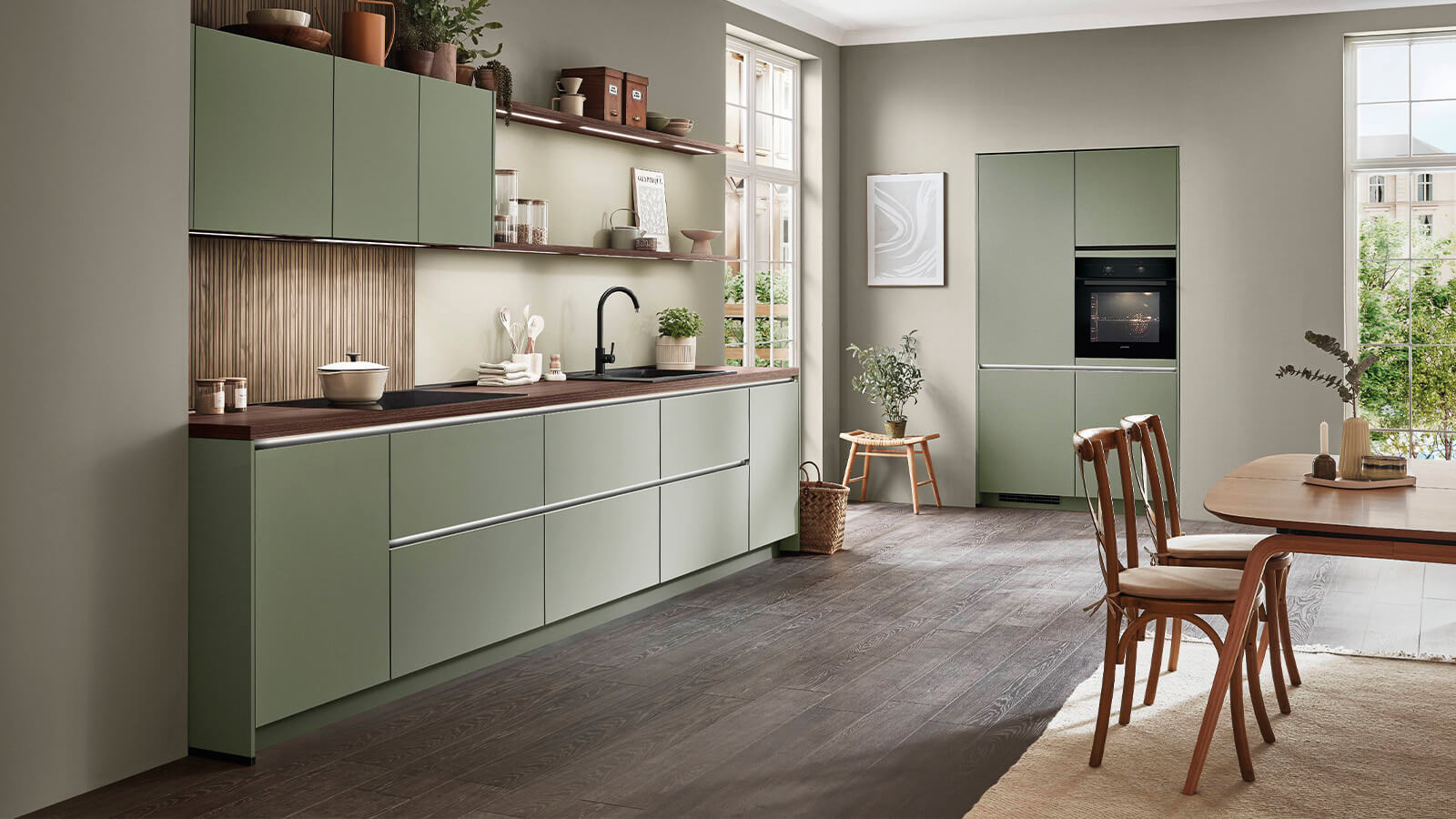 Zweizeilige Küche im EM-Senso-Design mit matten olivgrünen Lackfronten und Arbeitsplatte in Nussbaum-Milano-Nachbildung.