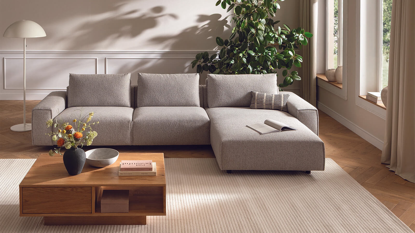 Graues Ecksofa mit Longchair rechts, Relaxfunktion und weicher Polsterung im modernen Design.