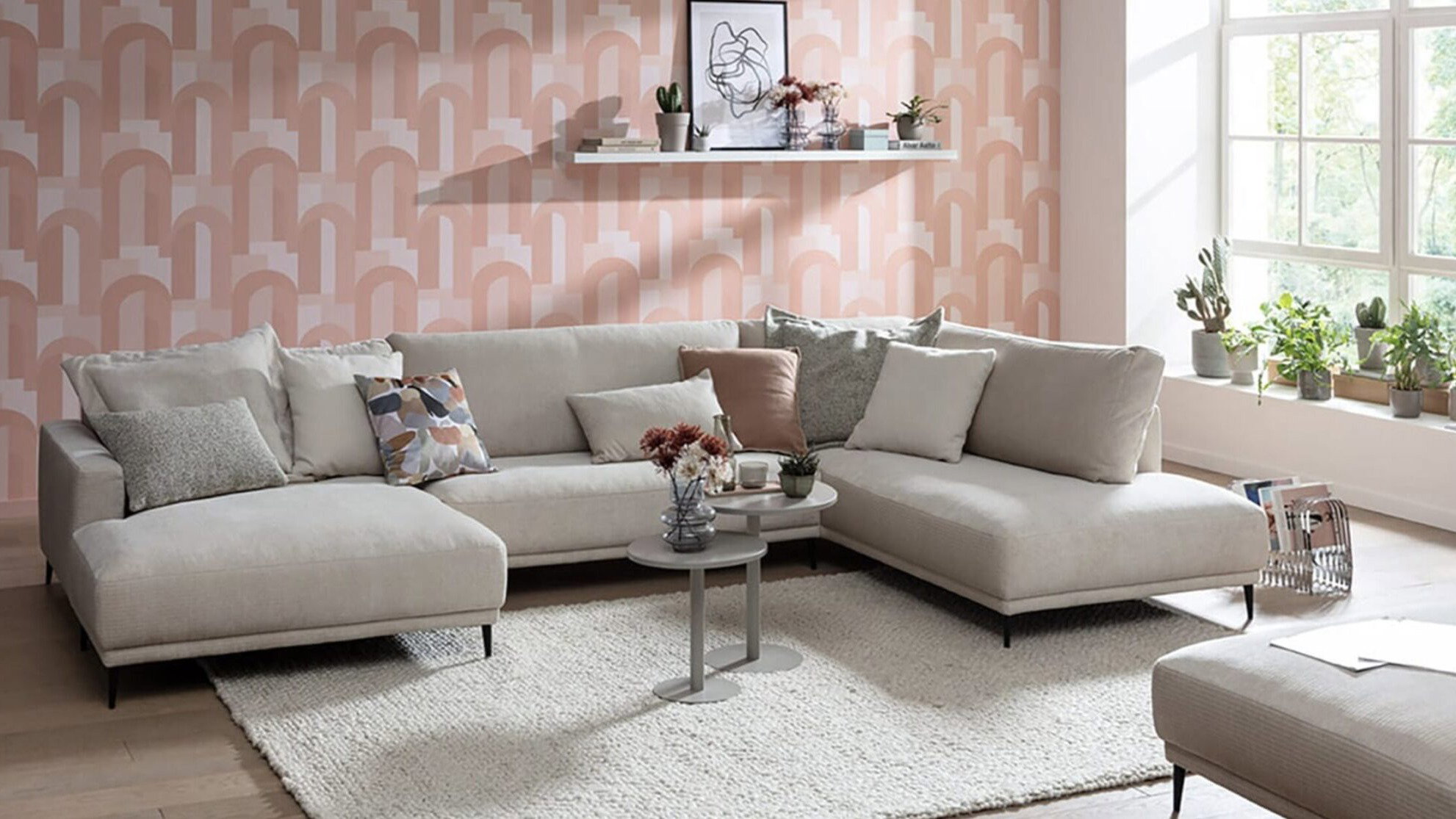 Helles Ecksofa im modernen Wohnzimmer mit Teppich, Couchtisch und großer Fensterfront als Beispiel für die richtige Möbelpositionierung im Wohnraum.