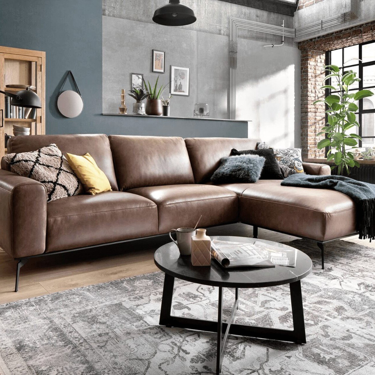 Braunes Leder-Ecksofa in einem modernen Wohnzimmer im Industrial-Stil.