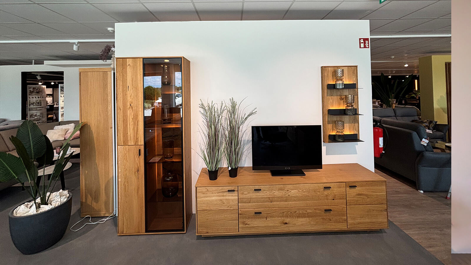 Wohnkombination aus Ast- und Balkeneiche mit beleuchtetem Highboard, Lowboard und Wandregal im modernen, natürlichen Design.