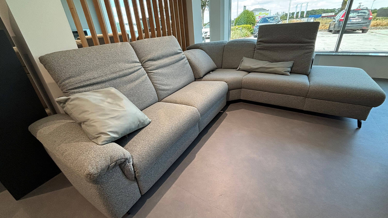Wohnlandschaft in Q2 Rustic Azuro mit Relaxfunktion, manuell verstellbaren Kopfteilen, Stauraumhocker, Kissen und anthrazitfarbener Metallkufe.