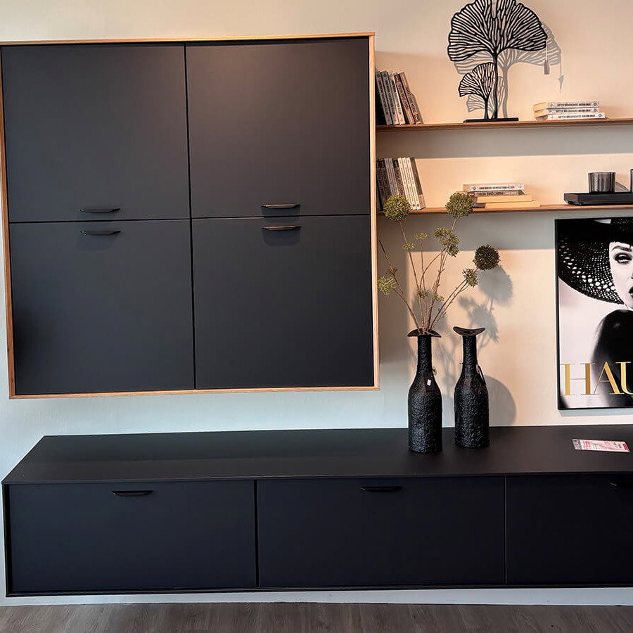 Moderne Wohnkombination mit graphitschwarzen Fronten, Holzakzenten in Eiche Sierra, Hängeschrank, Lowboard und Wandböden.