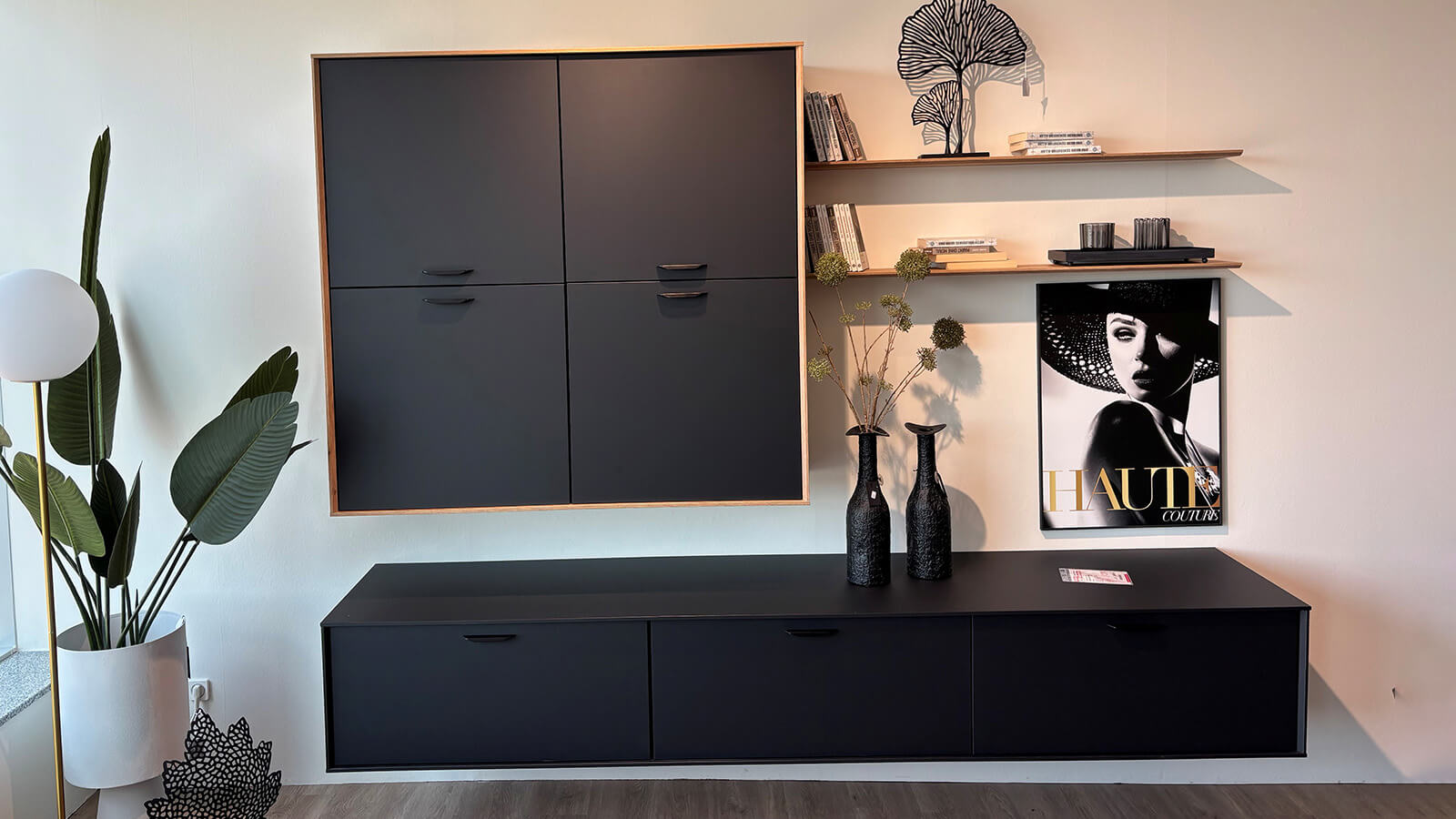 Moderne Wohnkombination mit graphitschwarzen Fronten, Holzakzenten in Eiche Sierra, Hängeschrank, Lowboard und Wandböden.
