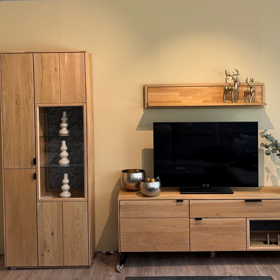 Moderne Wohnkombination aus Wildeiche massiv bianco mit Vitrine, Lowboard, Wandboard, integrierter Beleuchtung und Granit-Steinrückwand.