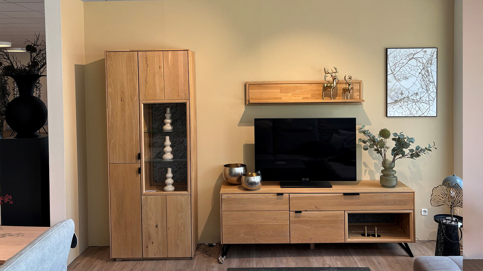 Moderne Wohnkombination aus Wildeiche massiv bianco mit Vitrine, Lowboard, Wandboard, integrierter Beleuchtung und Granit-Steinrückwand.