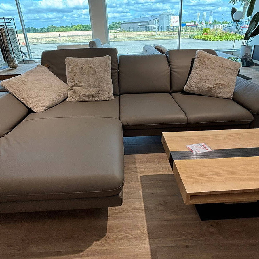 Moderne Wohnlandschaft in Leder Lava mit Longchair, verstellbaren Kopfstützen und schwarzen Metallfüßen.
