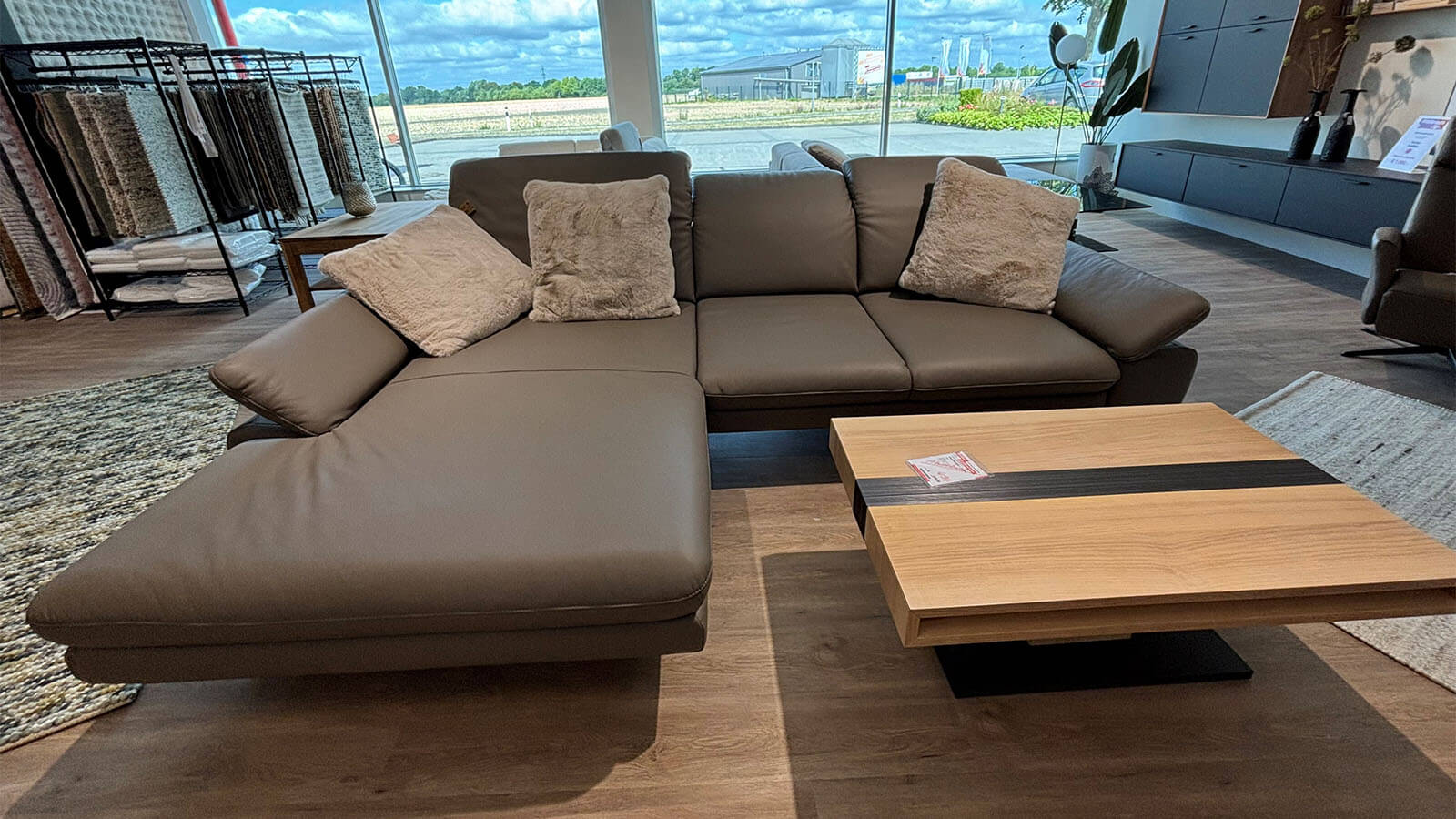 Moderne Wohnlandschaft in Leder Lava mit Longchair, verstellbaren Kopfstützen und schwarzen Metallfüßen.