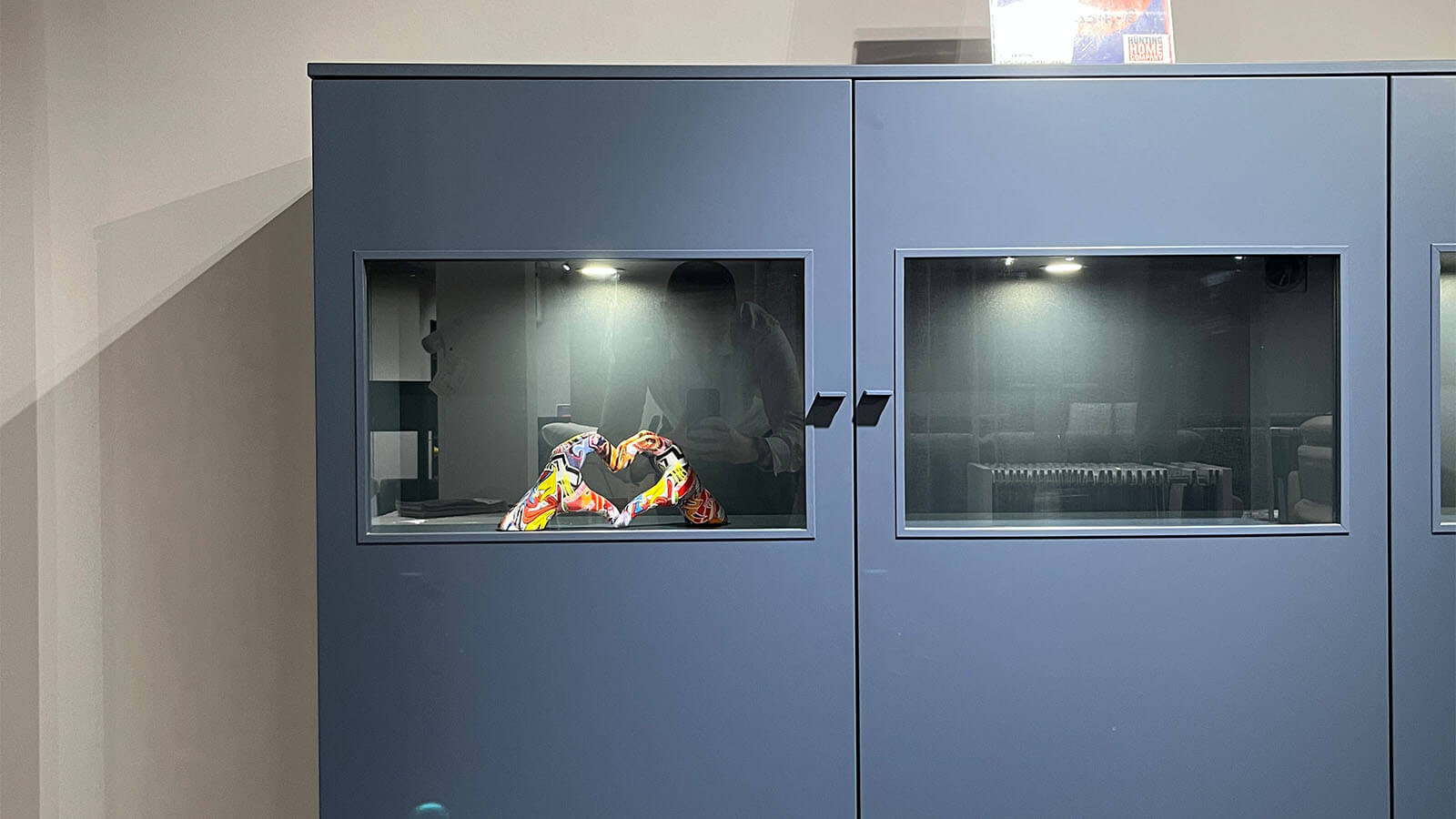 Breites Highboard in Atlantikblau mit hochwertiger Lackoberfläche, vier gleichmäßig angeordneten Frontsegmenten, farbgleichen Griffen und filigranem Kufengestell für eine klare, geradlinige Wohnraumgestaltung.