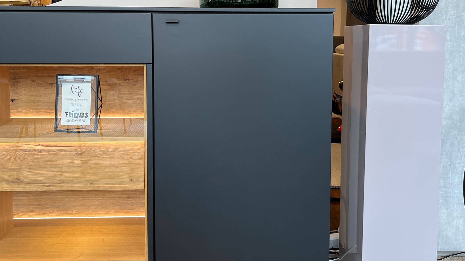 Großes Sideboard in mattem Anthrazit mit grifflosen Fronten, geölten Eiche-Massivholz-Akzenten und integrierter Beleuchtung