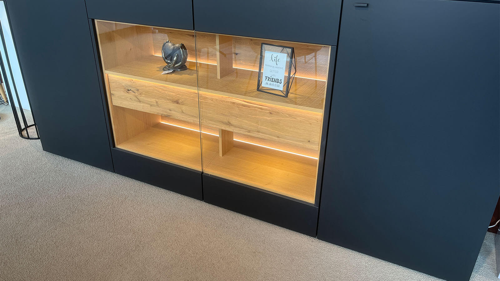 Großes Sideboard in mattem Anthrazit mit grifflosen Fronten, geölten Eiche-Massivholz-Akzenten und integrierter Beleuchtung