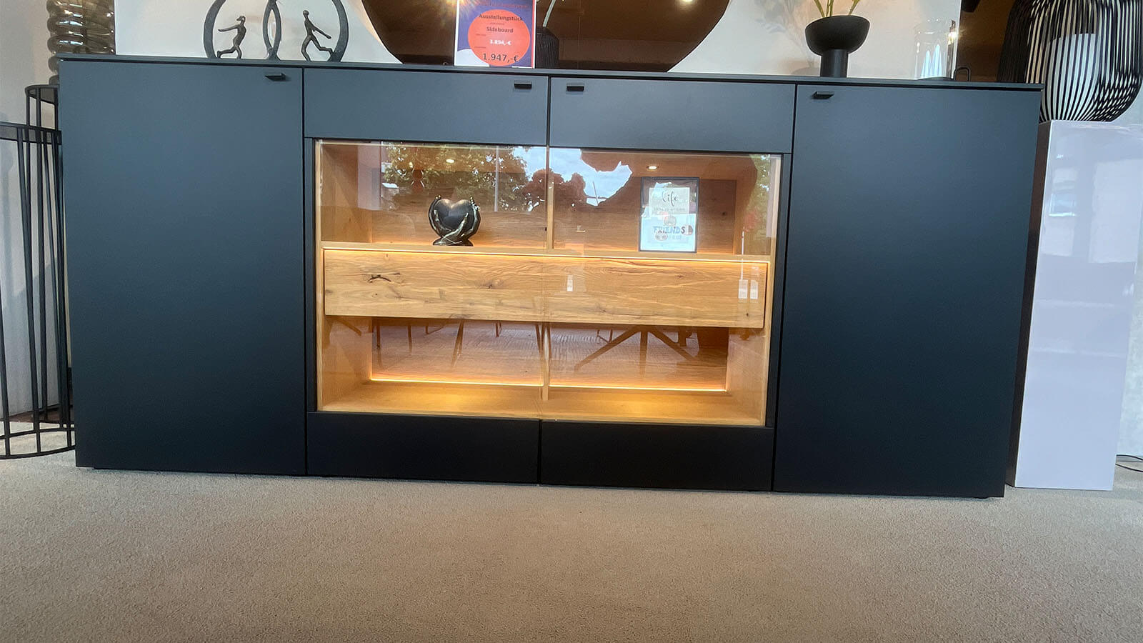 Großes Sideboard in mattem Anthrazit mit grifflosen Fronten, geölten Eiche-Massivholz-Akzenten und integrierter Beleuchtung
