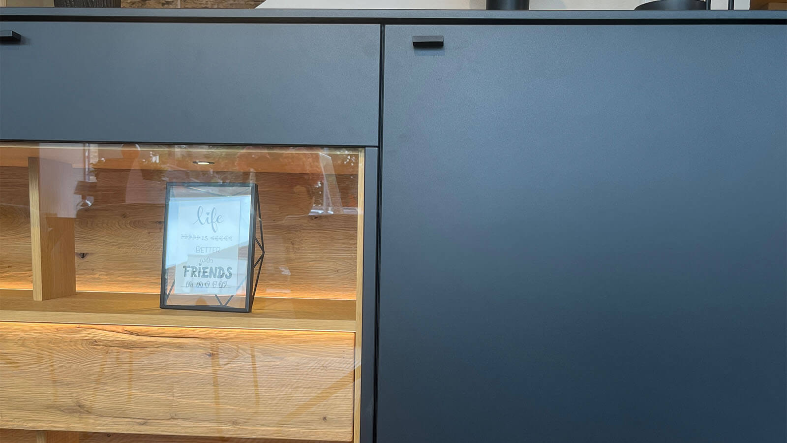 Großes Sideboard in mattem Anthrazit mit grifflosen Fronten, geölten Eiche-Massivholz-Akzenten und integrierter Beleuchtung