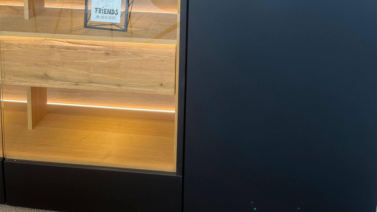 Großes Sideboard in mattem Anthrazit mit grifflosen Fronten, geölten Eiche-Massivholz-Akzenten und integrierter Beleuchtung