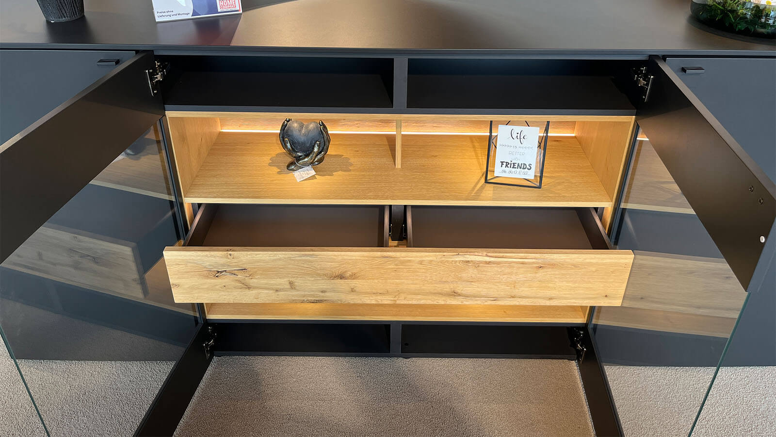 Großes Sideboard in mattem Anthrazit mit grifflosen Fronten, geölten Eiche-Massivholz-Akzenten und integrierter Beleuchtung