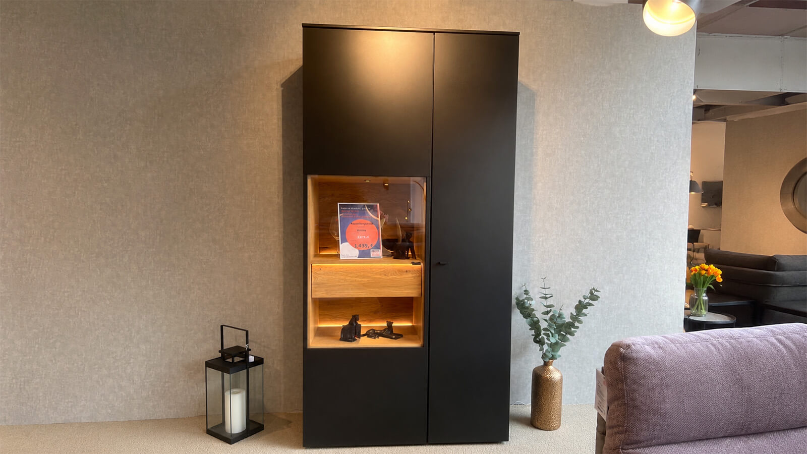 Hohe Vitrine in mattem Anthrazit mit grifflosen Türen, Akzenten aus geölter Massivholz-Eiche und stimmungsvoller Innenbeleuchtung