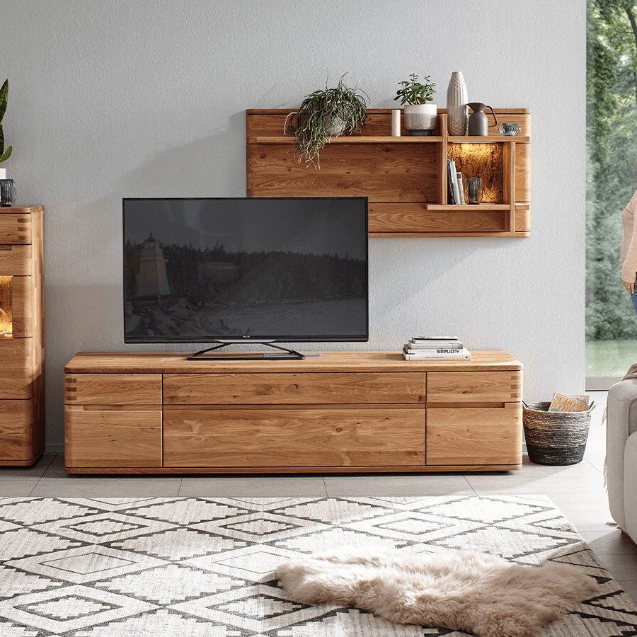 Massive Wohnwand Cartago Soft aus naturgeölter Wildeiche mit integriertem LED-beleuchtetem Wandpaneel und Highboard in wohnlicher Einrichtung
