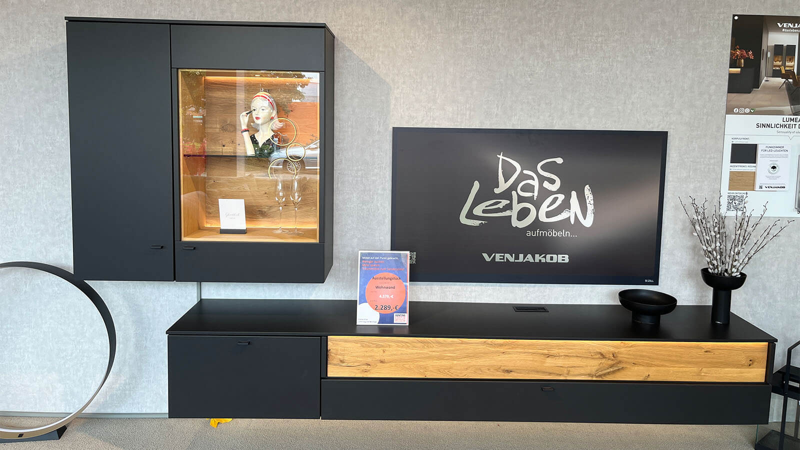 Moderne Wohnwand mit anthrazitfarbenem Mattlack, Akzenten aus geölter Eiche Massivholz, schwebendem Lowboard, Hängevitrine und stimmungsvoller LED-Beleuchtung.