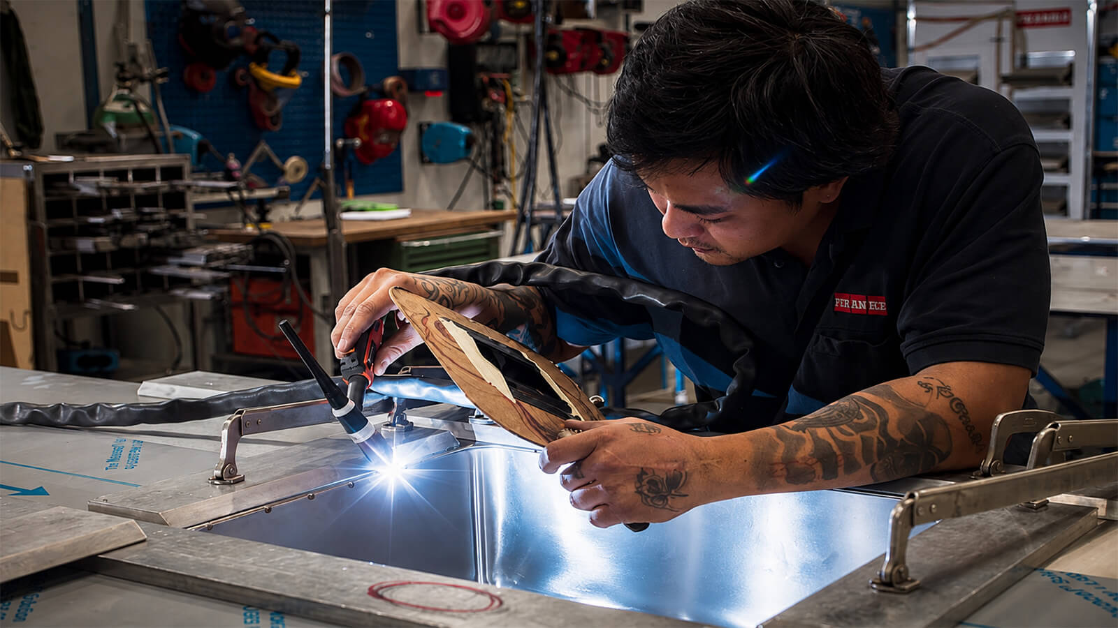 Mitarbeiter bei der pr&auml;zisen Metallbearbeitung und Schwei&szlig;arbeit an einer Edelstahlsp&uuml;le in der Produktion