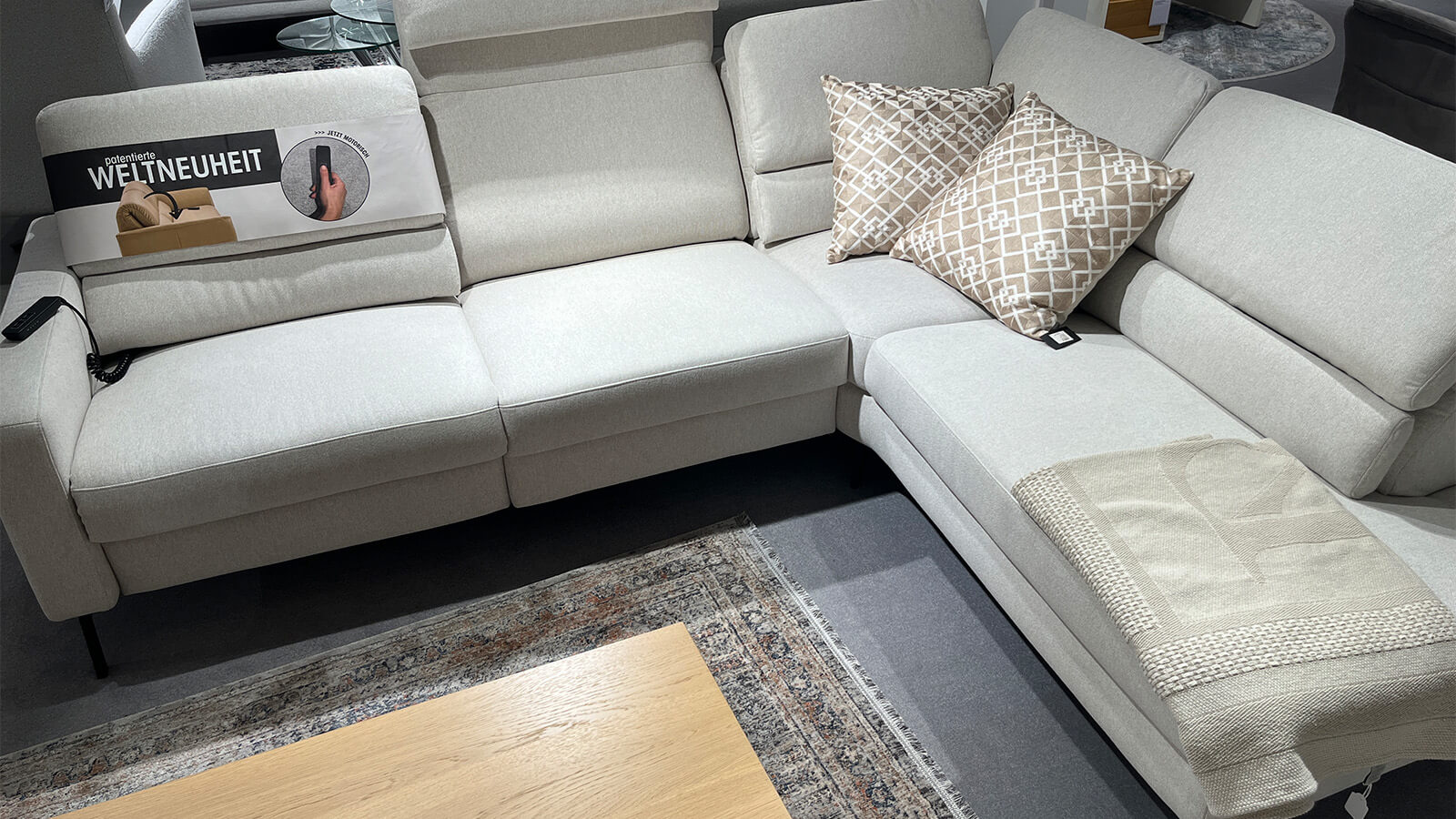 Großzügige Eckpolstergarnitur in naturfarbenem Stoffbezug Simply Clean Nature mit glatter Sitzfläche, schwarzem Metallfuß, verstellbaren Rückenlehnen, klarer Linienführung und komfortabler Relaxfunktion