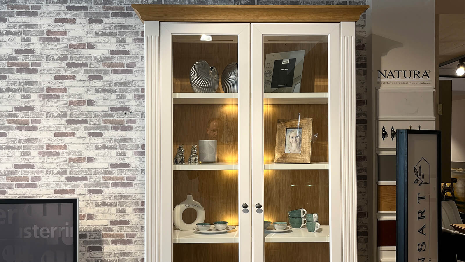 Wohnwand Maisonette in Weiß mit Asteiche-Akzenten, bestehend aus TV-Sideboard, Bar-Element und Vitrine mit integrierter Beleuchtung