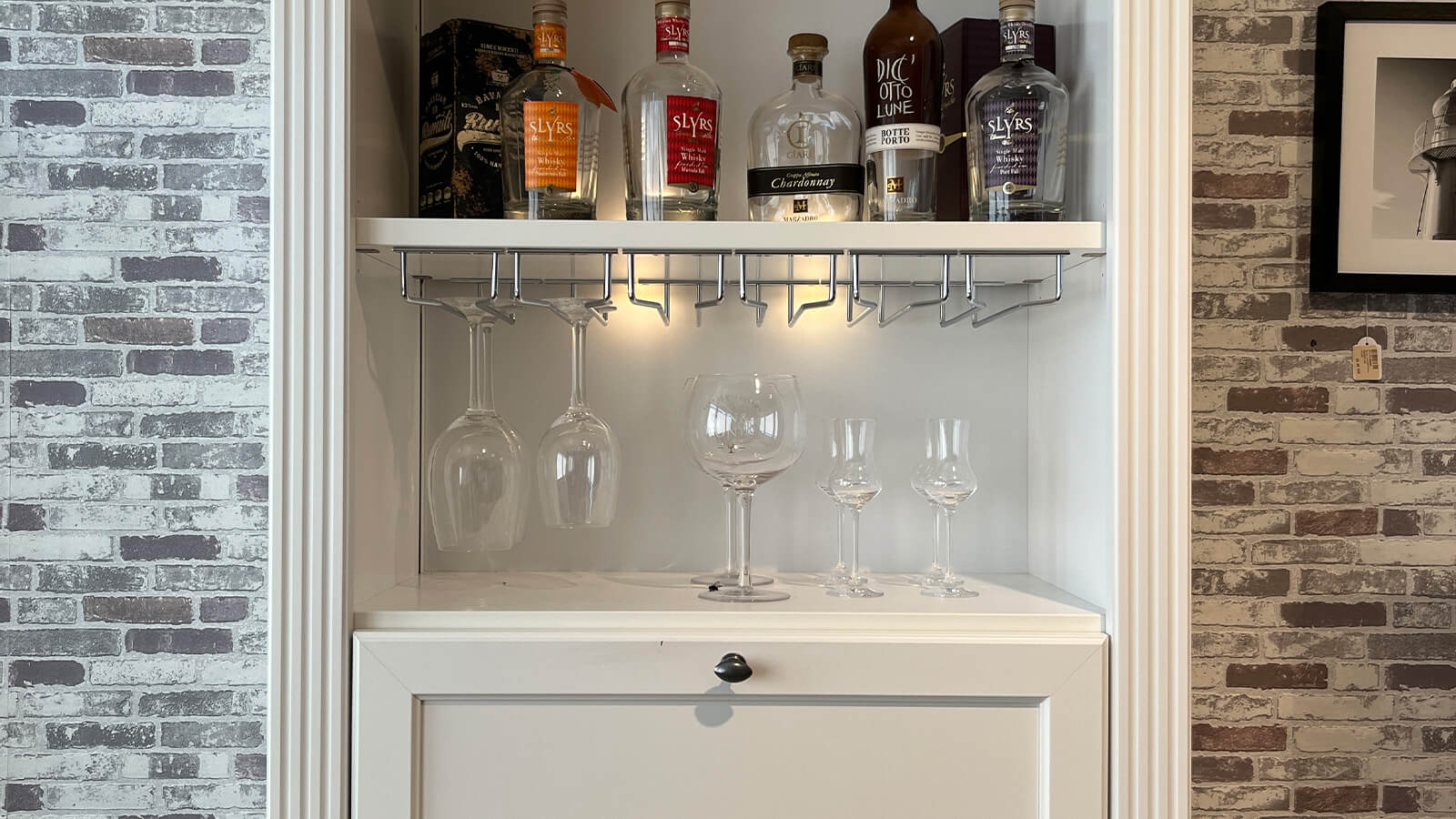 Wohnwand Maisonette in Weiß mit Asteiche-Akzenten, bestehend aus TV-Sideboard, Bar-Element und Vitrine mit integrierter Beleuchtung